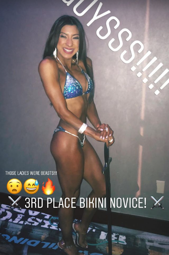 Latina Bikini Bodybuilder wins 3rd place and is holding a sword.