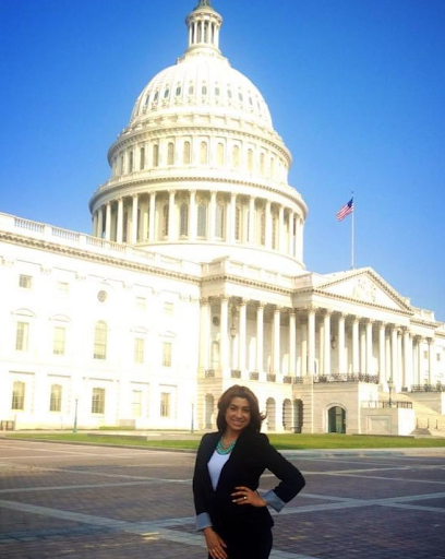 Latina Professional Stands Happily In front of white house